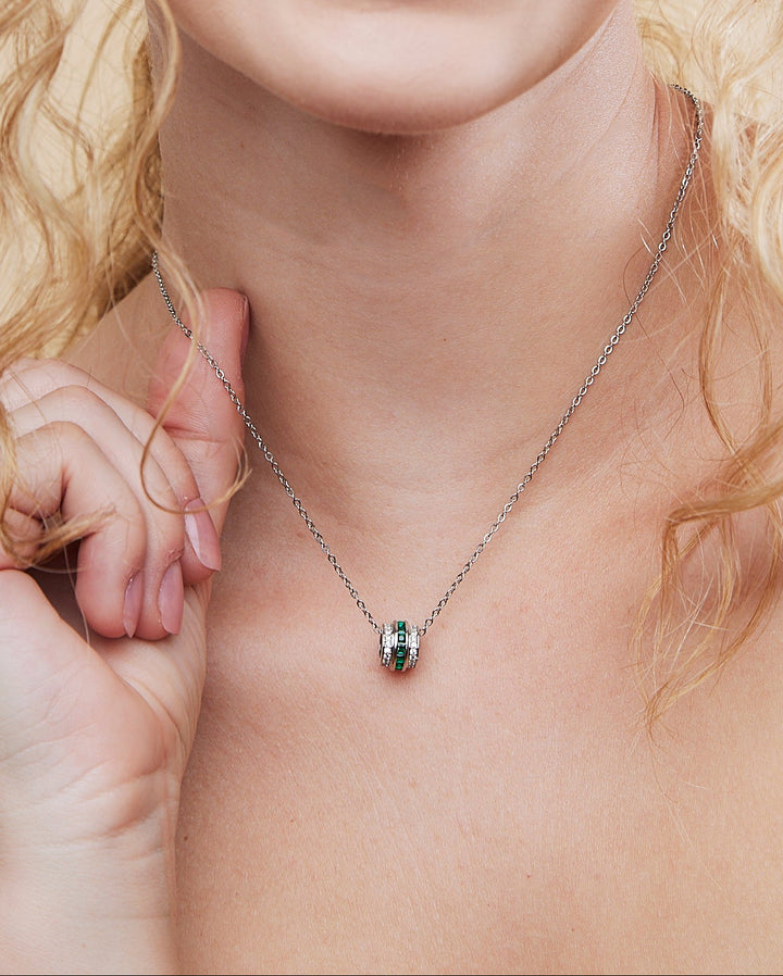 Woman wearing a necklace with a beige background