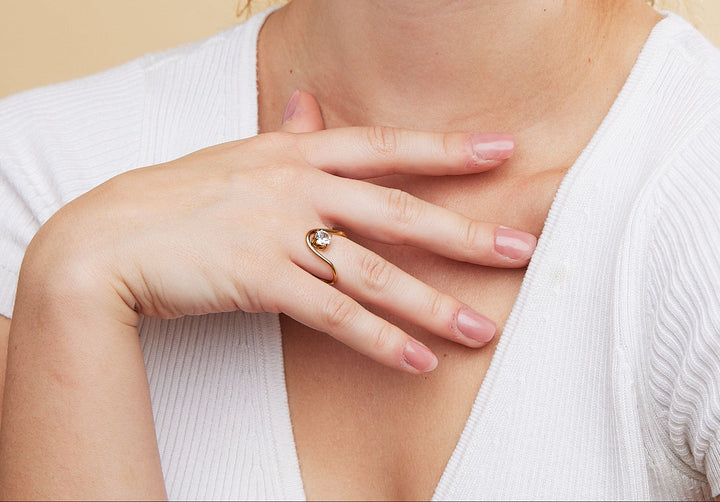 Woman wearing a ring on a beige background
